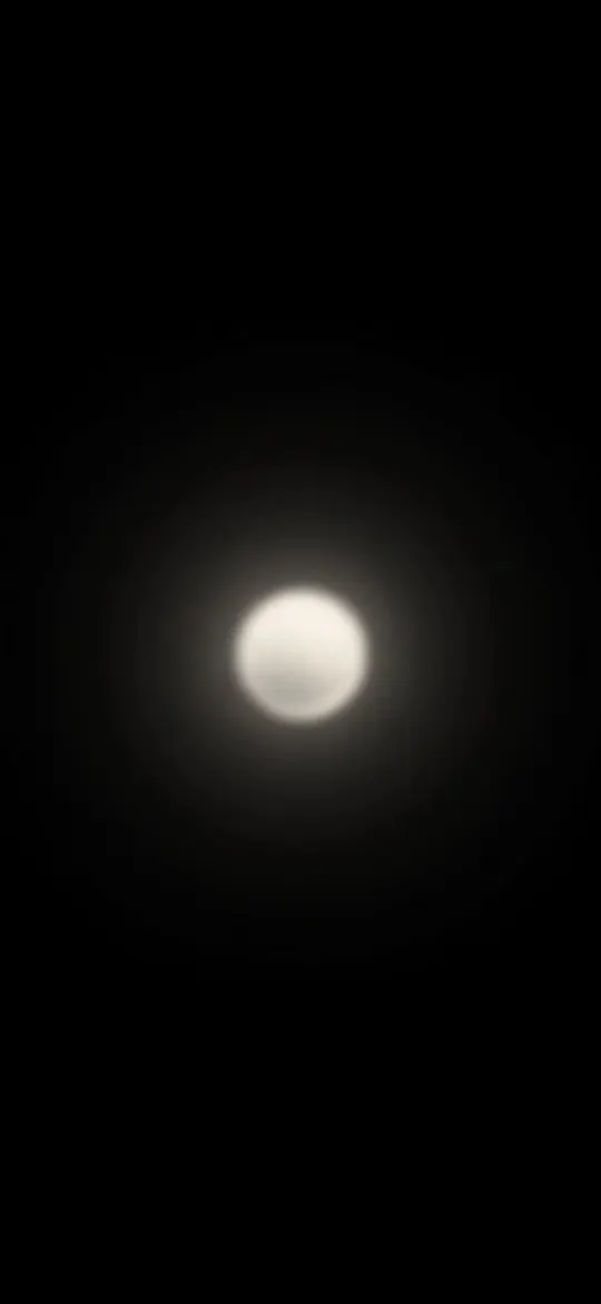 Soft glowing white orb with a faint halo in the centre of black