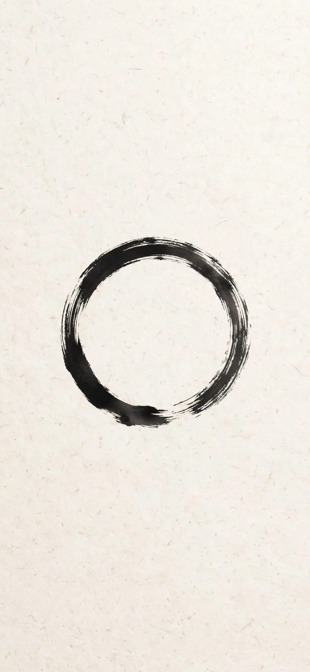 Black ink brush circle on textured beige rice paper