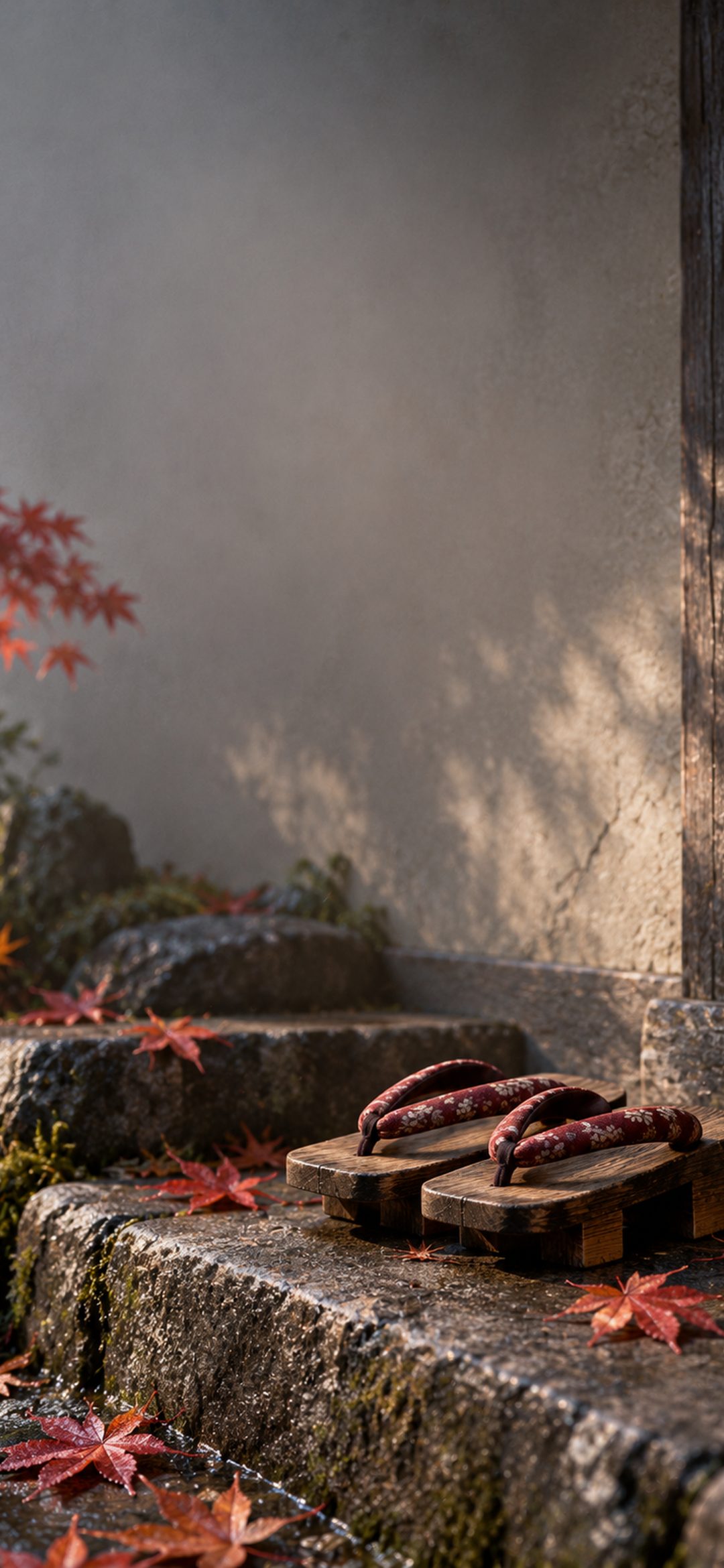 Wooden geta sandals on mossy stone steps with red maple leaves in soft sunlight