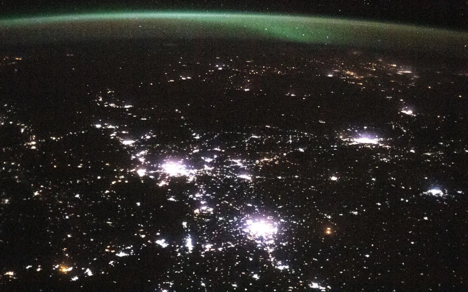 City lights scattered across the dark Earth at night, seen from space