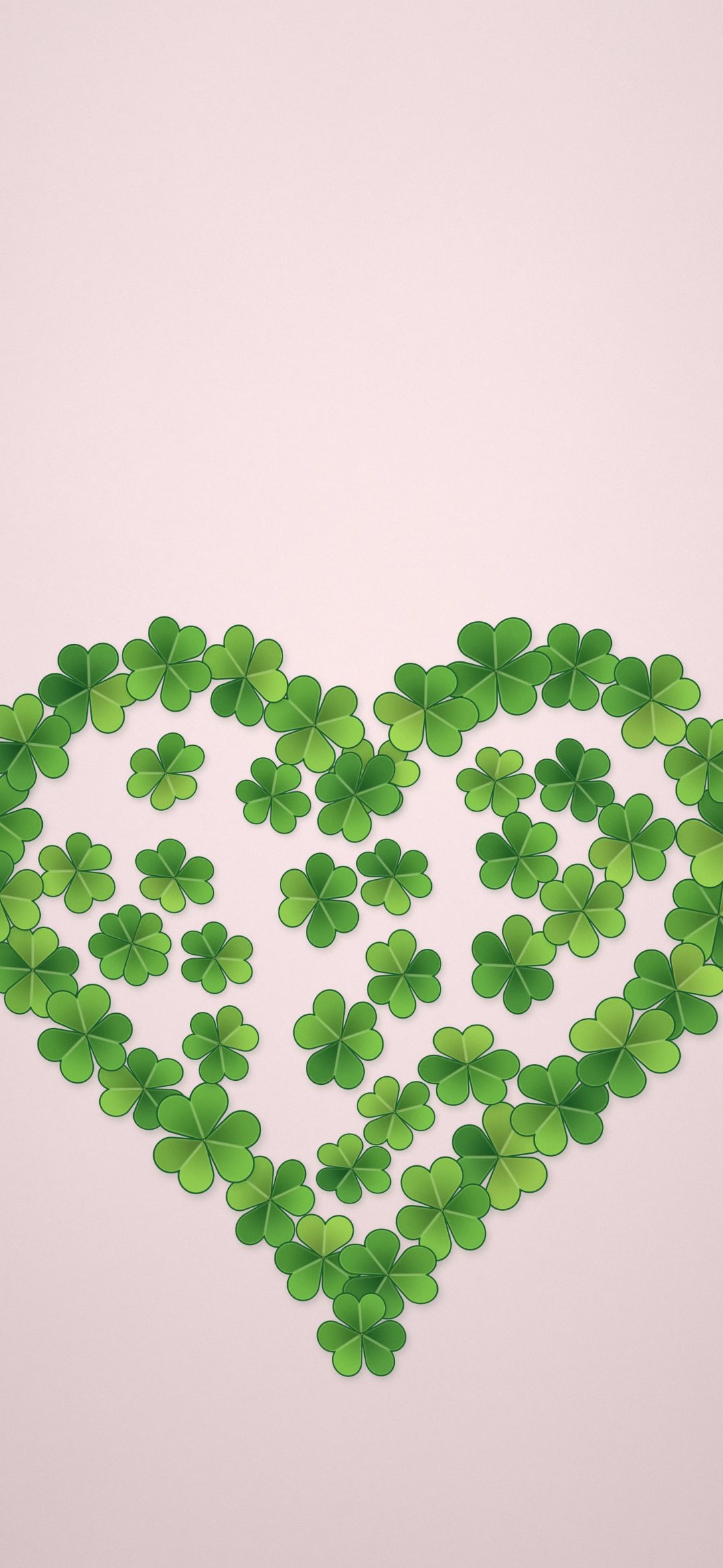 Clover Heart: dozens of small green clovers form a big heart shape on a soft blush background, iPhone wallpaper