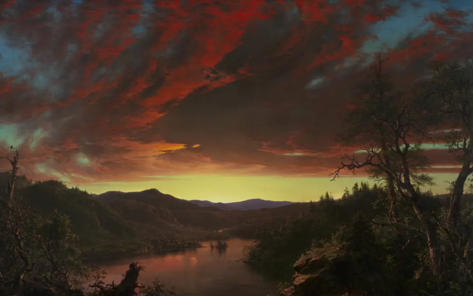 Fiery red sunset clouds over a dark forest lake and hills