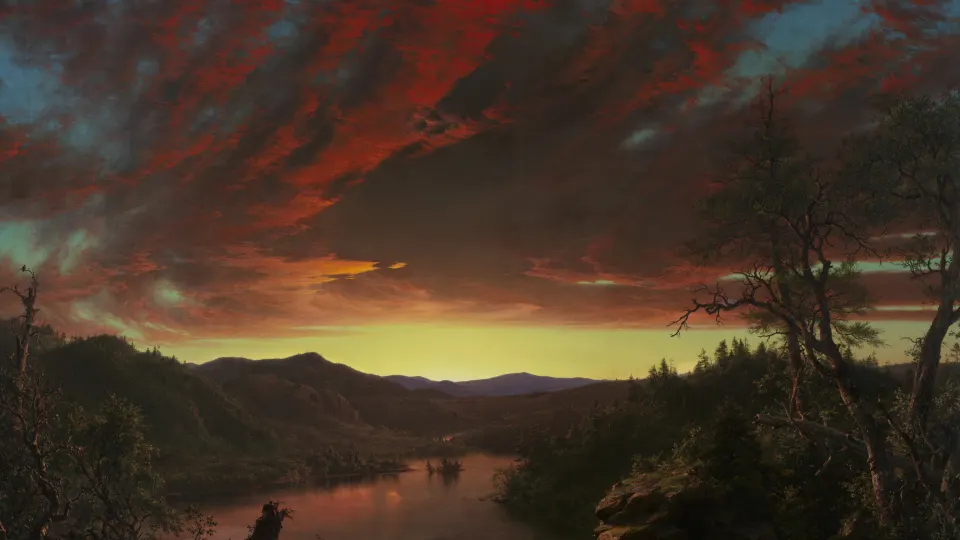 Fiery red sunset clouds over a dark forest lake and hills