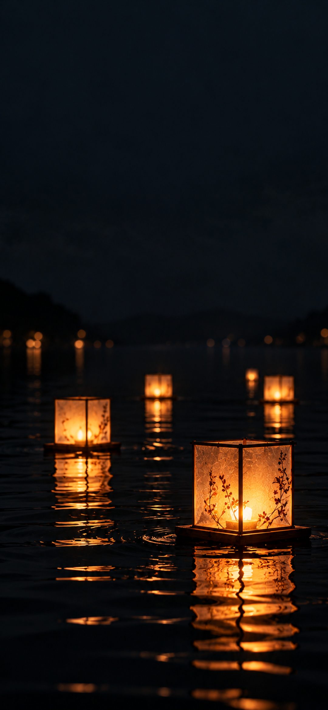 Glowing amber paper lanterns floating on dark water with shimmering golden reflections at night