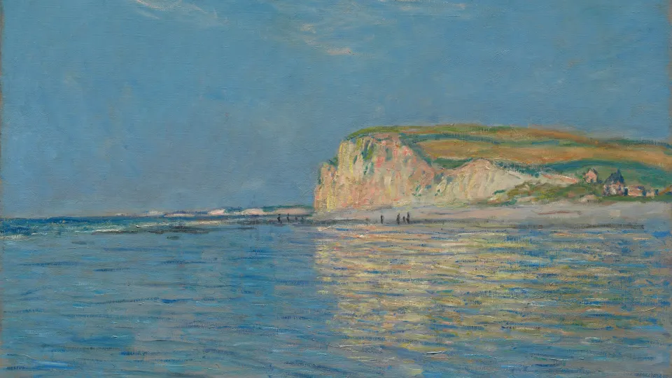 Calm blue sea at low tide with a pale cliff on the horizon