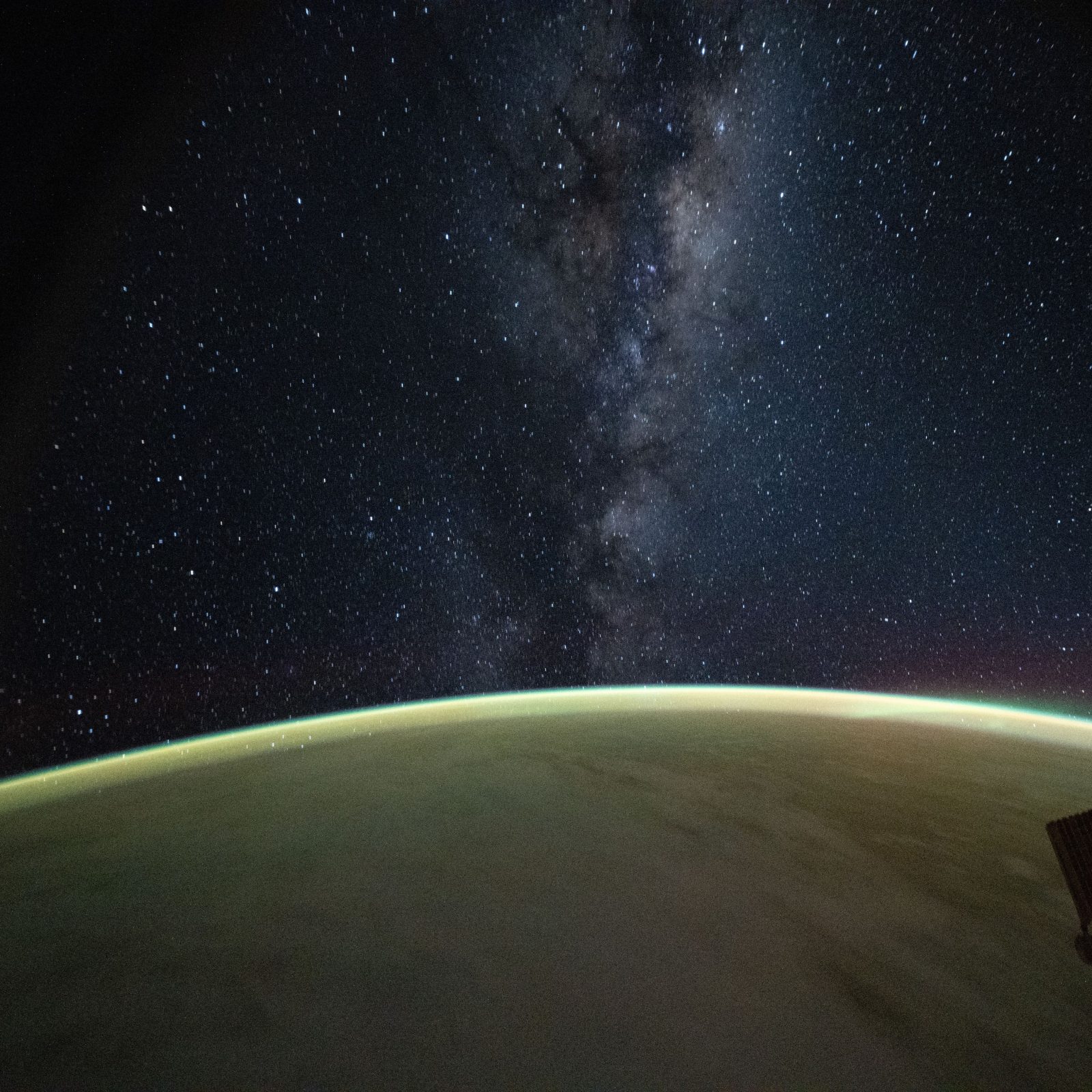 Milky Way stars above the glowing edge of Earth at night