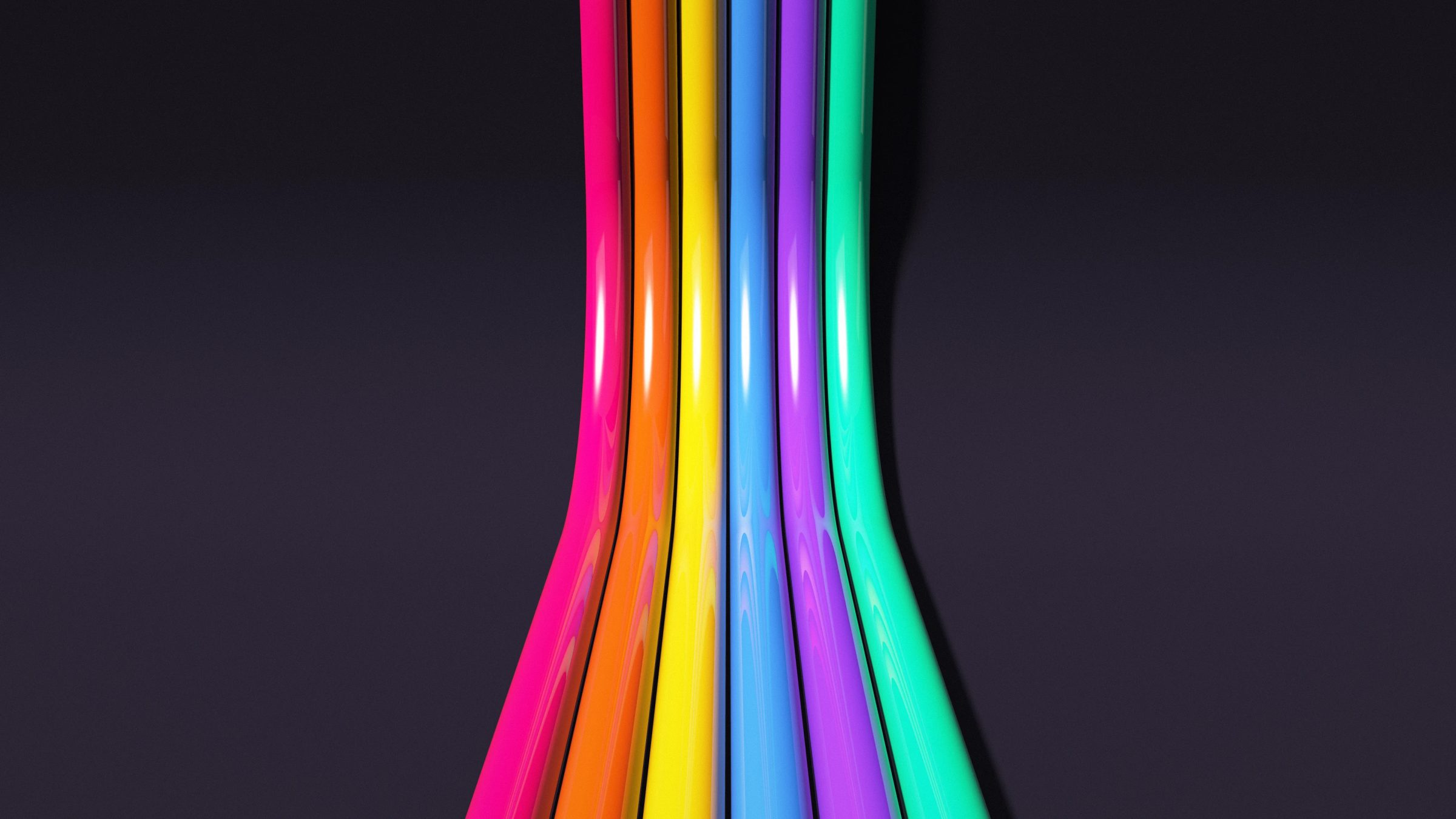 Neon Tubes After Dark: pink, orange, yellow, blue, purple and green glossy tubes run across a dark studio and rise up its curved back wall, PC wallpaper