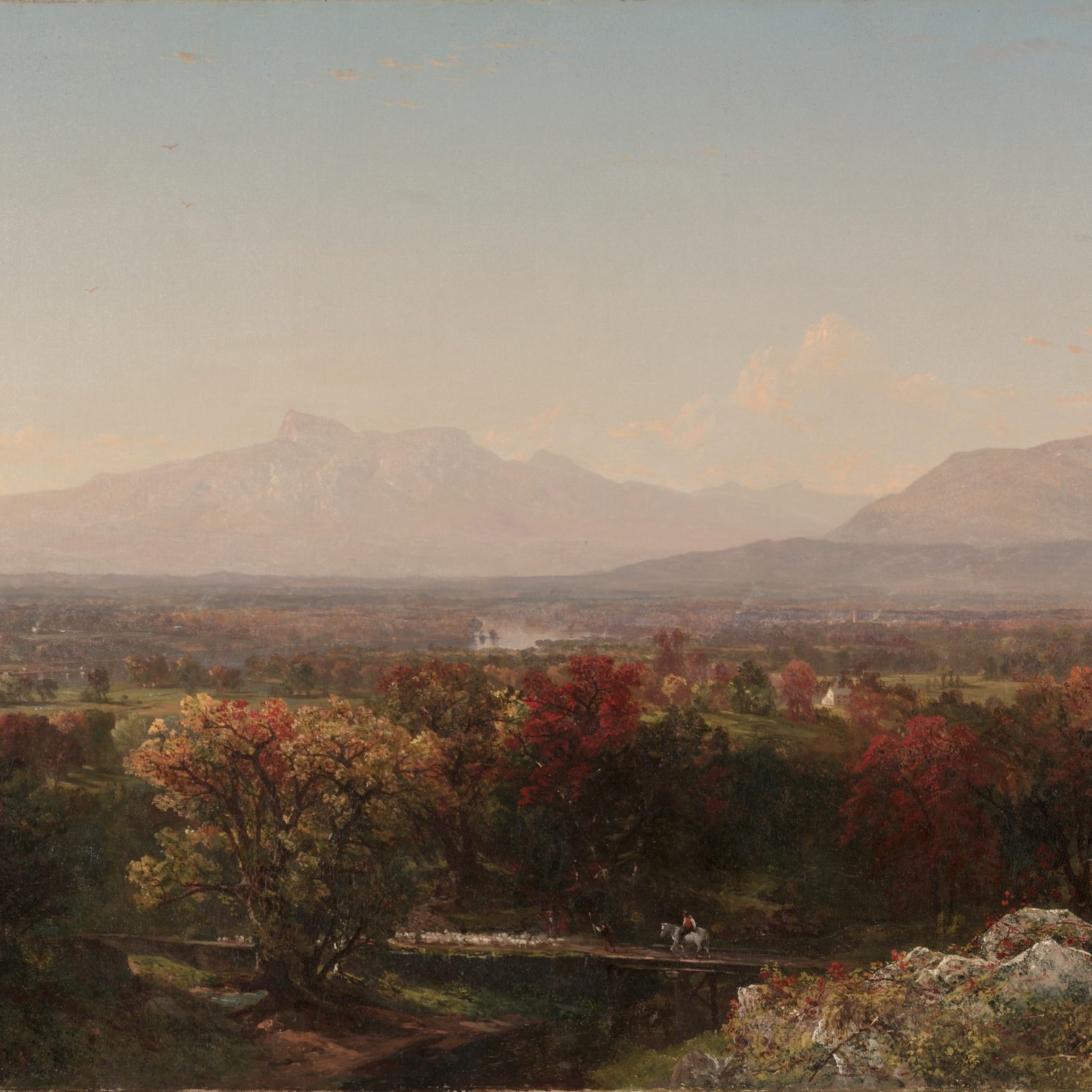 Red and orange autumn valley with blue mountains in the distance