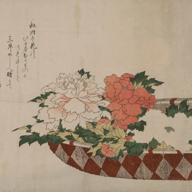 Pink and red peonies in a woven basket on cream paper