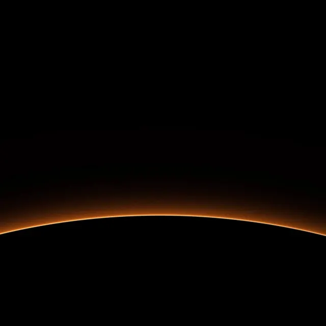 Red Planet Rim: a thin orange rim of light outlines the edge of a dark planet, warm haze rising softly into the surrounding black, iPad wallpaper