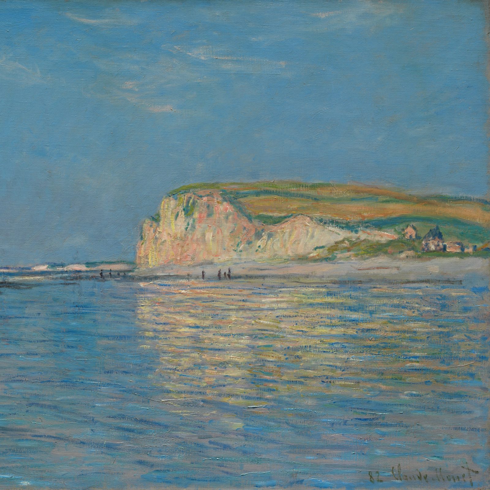 Pale chalk cliff above calm blue water at low tide