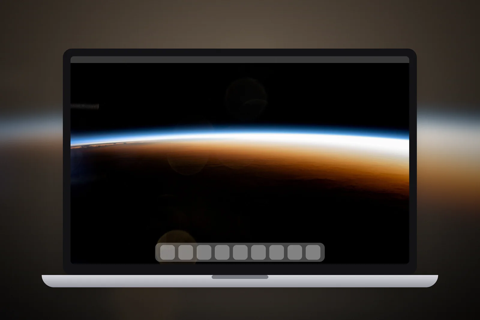 A Mac laptop showing the Orbital Sunrise Horizon wallpaper on its desktop