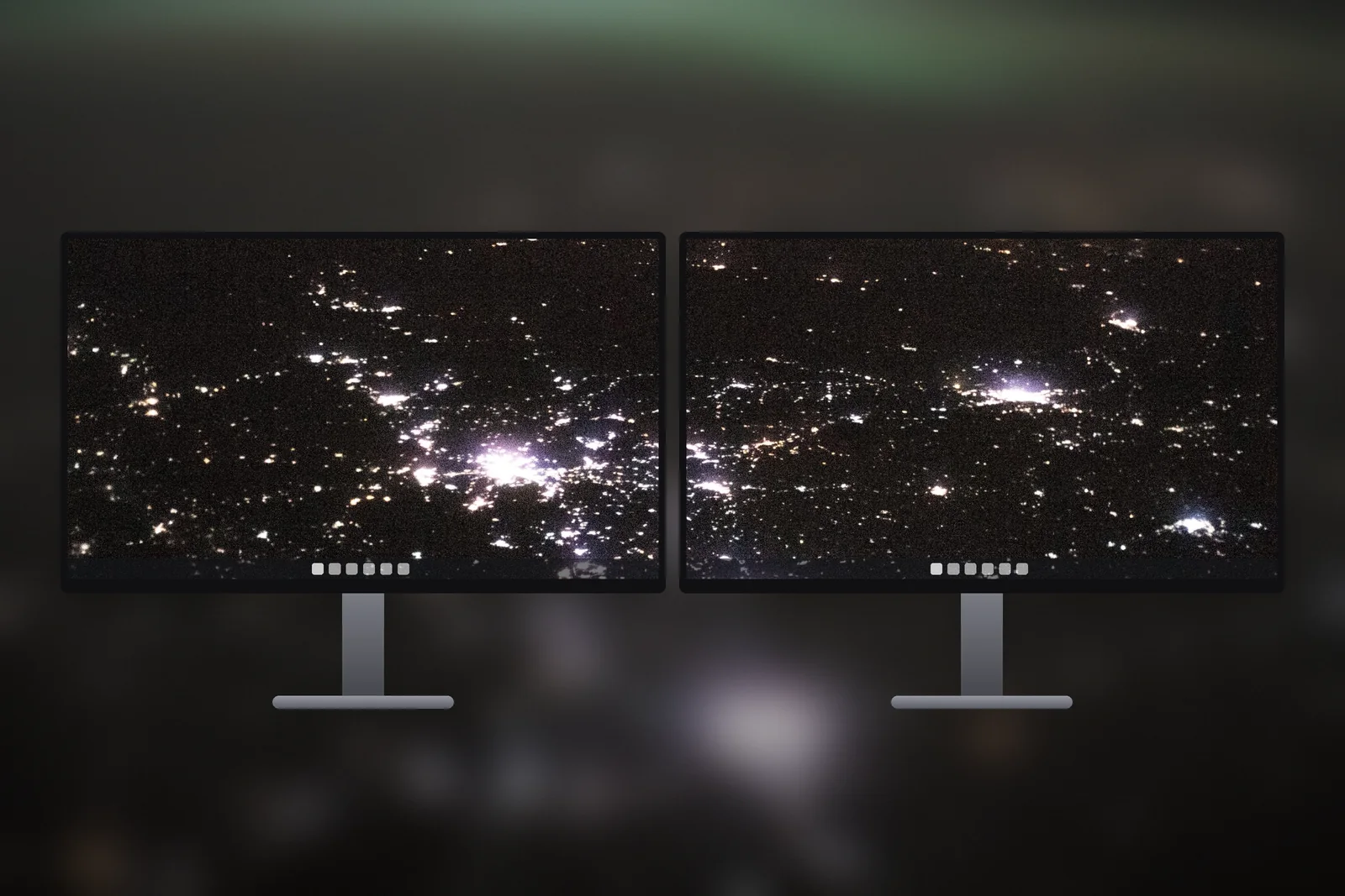 Two monitors side by side sharing the City Lights From Space wallpaper